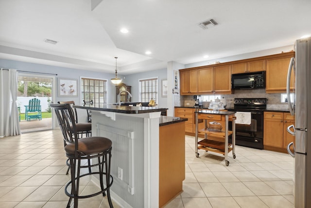 100 Kensington Cir, Panama City Beach, FL 32413 - kitchen featuring black appliances, dark countertops, a breakfast bar area, light tile patterned floors, and recessed lighting