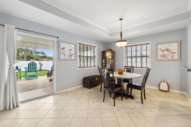 100 Kensington Cir, Panama City Beach, FL 32413 - dining area with healthy amount of natural light, a tray ceiling, baseboards, and crown molding