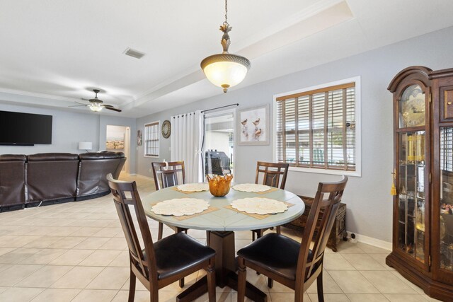 100 Kensington Cir, Panama City Beach, FL 32413 - dining area featuring a raised ceiling, light tile patterned flooring, a ceiling fan, and baseboards