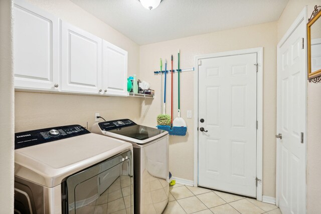 100 Kensington Cir, Panama City Beach, FL 32413 - clothes washing area with washer and clothes dryer, cabinet space, light tile patterned flooring, and baseboards