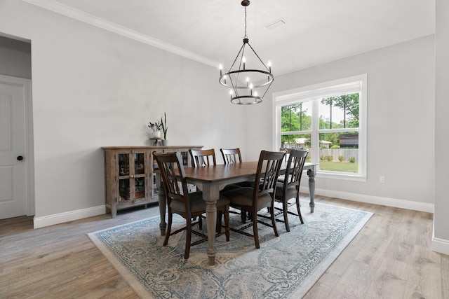 5362 Wyndell Cir, Crestview, FL 32539 - dining area with baseboards, a chandelier, light wood-style floors, and ornamental molding