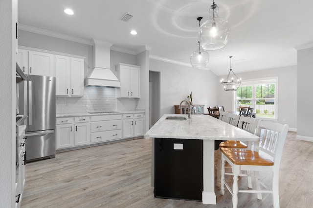 5362 Wyndell Cir, Crestview, FL 32539 - kitchen featuring freestanding refrigerator, custom exhaust hood, a sink, black electric cooktop, and a breakfast bar area