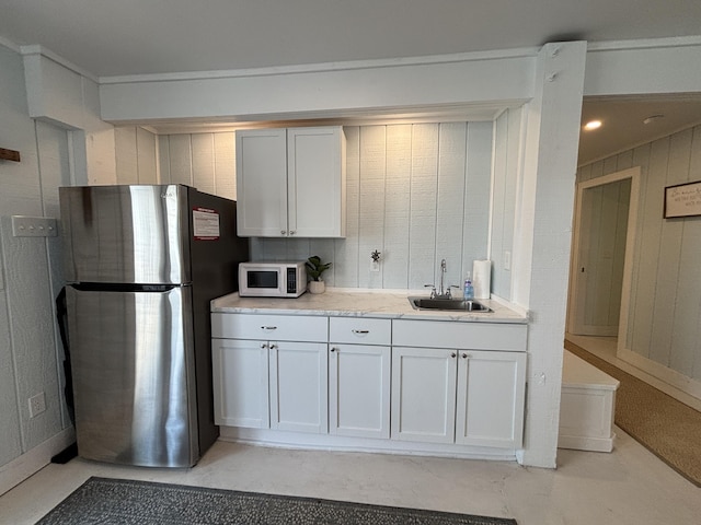101 Barbados Dr, Cape San Blas, FL 32456 - kitchen featuring a sink, freestanding refrigerator, white microwave, and white cabinetry