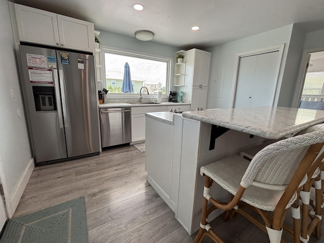 101 Barbados Dr, Cape San Blas, FL 32456 - kitchen with stainless steel appliances, a sink, white cabinetry, a kitchen bar, and recessed lighting