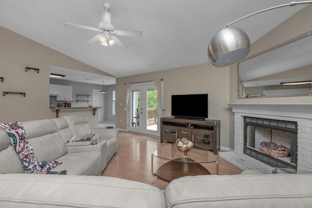 712 Riva Ridge Dr, Crestview, FL 32539 - living room with lofted ceiling, wood finished floors, a ceiling fan, and a fireplace