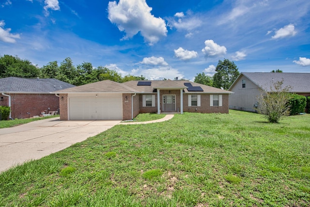 712 Riva Ridge Dr, Crestview, FL 32539 - ranch-style home with brick siding, an attached garage, roof mounted solar panels, a front lawn, and concrete driveway