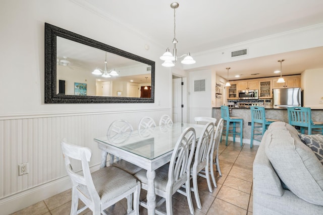 9100 Baytowne Wharf Blvd Unit 366-8, Miramar Beach, FL 32550 - dining room featuring crown molding, a chandelier, light tile patterned floors, and wainscoting
