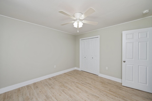 6859 Bill Lundy Rd, Laurel Hill, FL 32567 - unfurnished bedroom featuring light wood finished floors, a closet, baseboards, and a ceiling fan