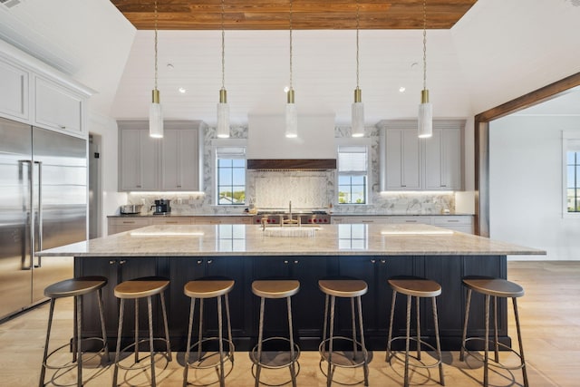 5012 W County Highway 30a, Santa Rosa Beach, FL 32459 - kitchen with built in fridge, light wood-style floors, a large island with sink, backsplash, and wooden ceiling