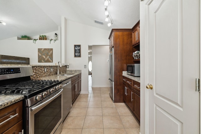 187 Sandy Cay Dr, Miramar Beach, FL 32550 - kitchen featuring stainless steel appliances, a sink, a textured ceiling, lofted ceiling, and light stone counters