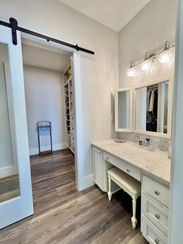 275 Lake Holley Cir, Defuniak Springs, FL 32433 - bathroom with wood finished floors, vanity, a walk in closet, and baseboards