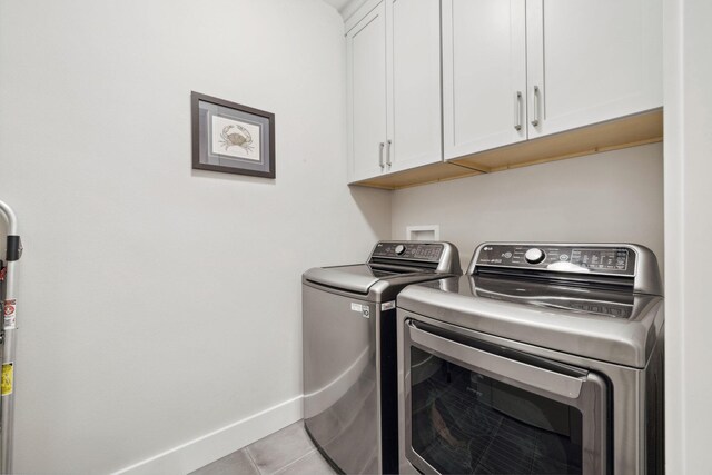 327 Cobalt Ln, Miramar Beach, FL 32550 - clothes washing area featuring washing machine and dryer, cabinet space, baseboards, and light tile patterned floors