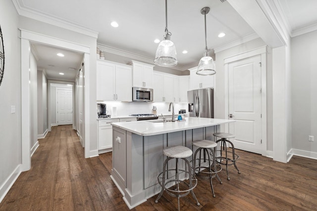 327 Cobalt Ln, Miramar Beach, FL 32550 - kitchen with stainless steel appliances, a sink, dark wood finished floors, light countertops, and a breakfast bar area