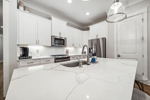 327 Cobalt Ln, Miramar Beach, FL 32550 - kitchen featuring stainless steel appliances, a sink, crown molding, white cabinetry, and decorative backsplash