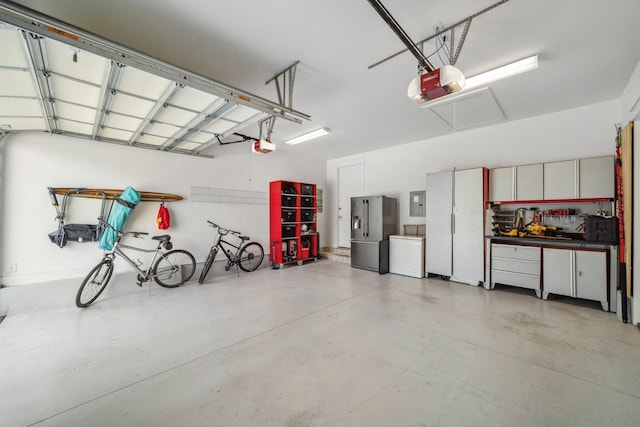 327 Cobalt Ln, Miramar Beach, FL 32550 - garage featuring stainless steel fridge with ice dispenser, a garage door opener, electric panel, and washer / clothes dryer