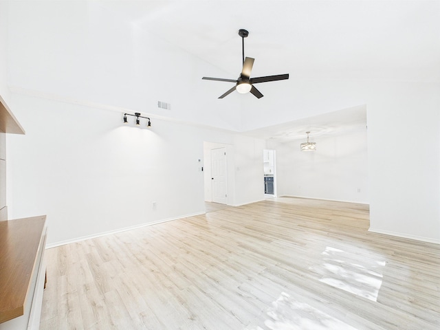 1000 Bay Dr Unit 524, Niceville, FL 32578 - unfurnished living room with a ceiling fan, a high ceiling, light wood-type flooring, a chandelier, and baseboards