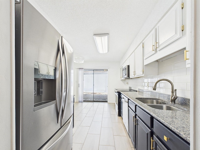 1000 Bay Dr Unit 524, Niceville, FL 32578 - kitchen featuring stainless steel appliances, a sink, white cabinetry, and backsplash