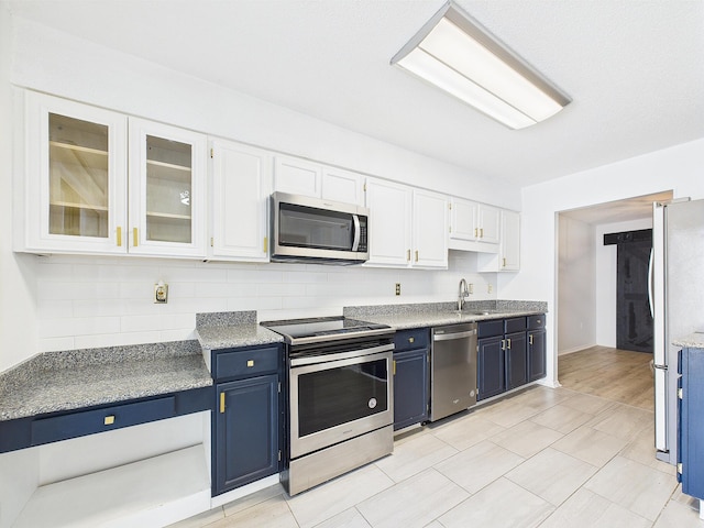 1000 Bay Dr Unit 524, Niceville, FL 32578 - kitchen featuring stainless steel appliances, blue cabinets, white cabinets, and a sink