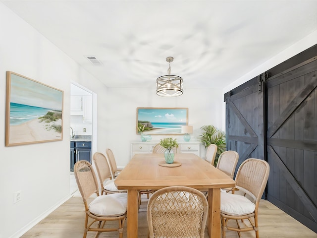 1000 Bay Dr Unit 524, Niceville, FL 32578 - dining space featuring light wood-style floors, a barn door, and baseboards
