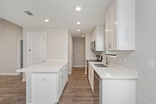 192 S Norwood Rd, Defuniak Springs, FL 32435 - kitchen with appliances with stainless steel finishes, a sink, wood finished floors, white cabinets, and recessed lighting
