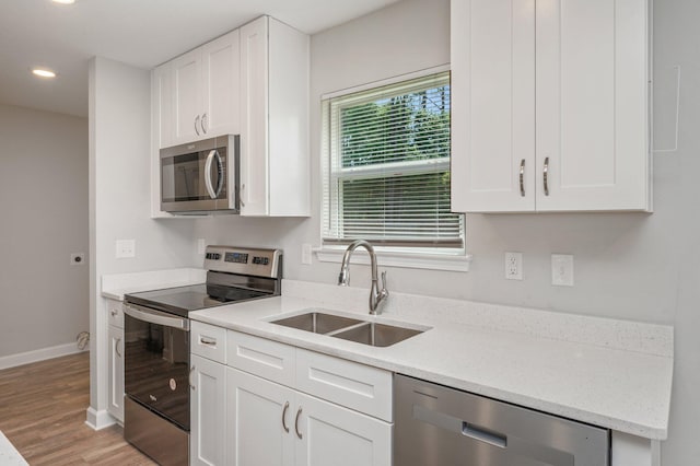 192 S Norwood Rd, Defuniak Springs, FL 32435 - kitchen featuring stainless steel appliances, a sink, light wood finished floors, white cabinets, and recessed lighting