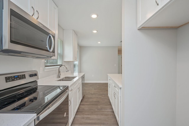 192 S Norwood Rd, Defuniak Springs, FL 32435 - kitchen with appliances with stainless steel finishes, light wood-type flooring, a sink, recessed lighting, and white cabinetry