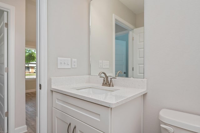 192 S Norwood Rd, Defuniak Springs, FL 32435 - bathroom with toilet, vanity, wood finished floors, and baseboards