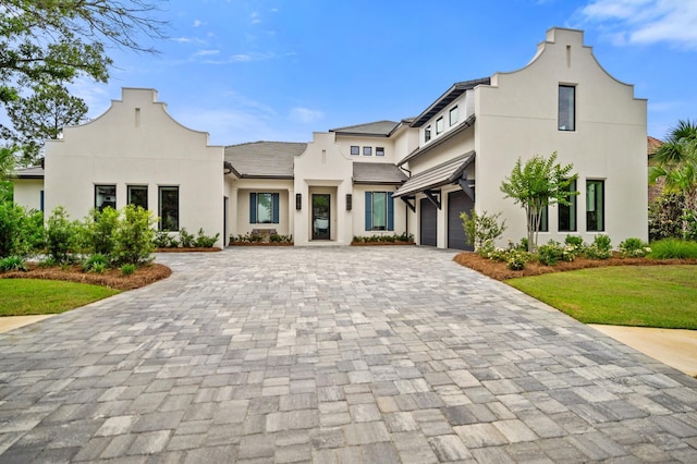 3502 Burnt Pine Ln, Miramar Beach, FL 32550 - view of front of home with decorative driveway, a garage, stucco siding, and a front lawn