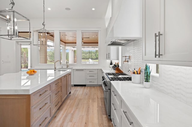 3502 Burnt Pine Ln, Miramar Beach, FL 32550 - kitchen featuring high end stove, custom exhaust hood, a chandelier, light wood-type flooring, and backsplash