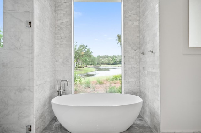 3502 Burnt Pine Ln, Miramar Beach, FL 32550 - bathroom with a freestanding tub, marble tiled floors, a water view, and tile walls