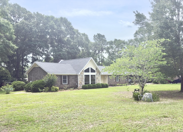 mid-century inspired home featuring stone siding and a front yard