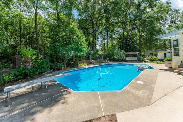 6087 Terrace Ln, Crestview, FL 32536 - outdoor pool featuring a diving board, a patio, and view of wooded area