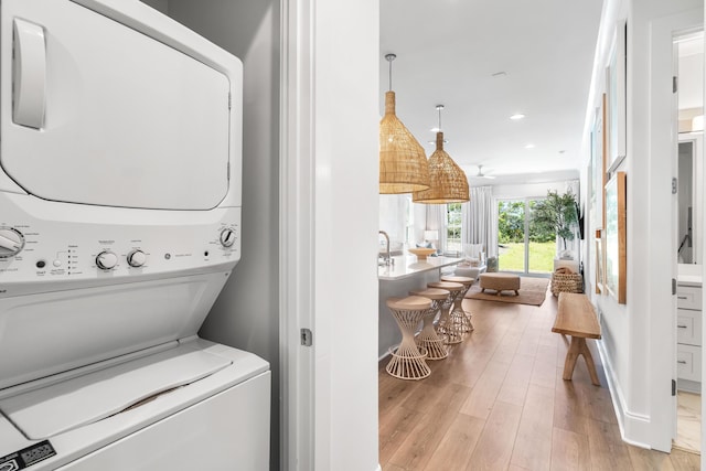 70 Martha S Ln # 2-101, Santa Rosa Beach, FL 32459 - laundry area with stacked washer and clothes dryer, light wood finished floors, recessed lighting, and baseboards