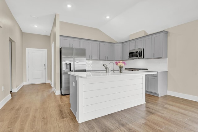 262 Bayou Bend Ln, Panama City, FL 32404 - kitchen featuring appliances with stainless steel finishes, gray cabinetry, light countertops, a kitchen island with sink, and backsplash