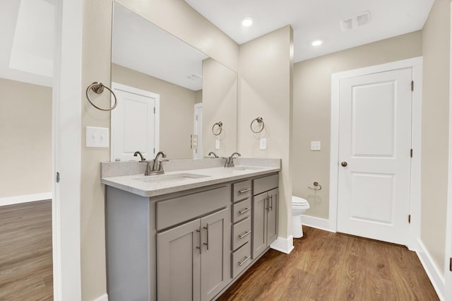 262 Bayou Bend Ln, Panama City, FL 32404 - bathroom featuring toilet, wood finished floors, double vanity, and baseboards