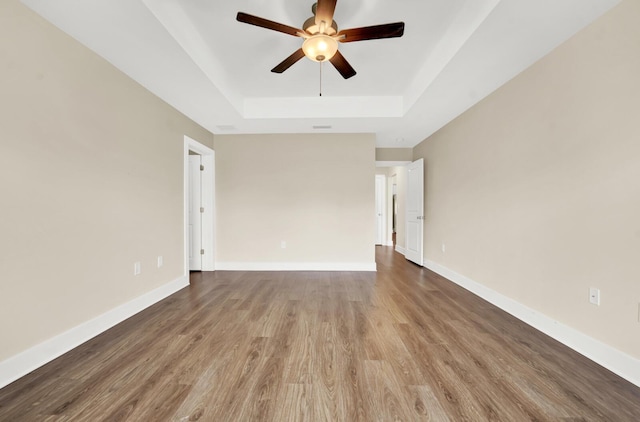 262 Bayou Bend Ln, Panama City, FL 32404 - empty room with a raised ceiling, wood finished floors, ceiling fan, and baseboards