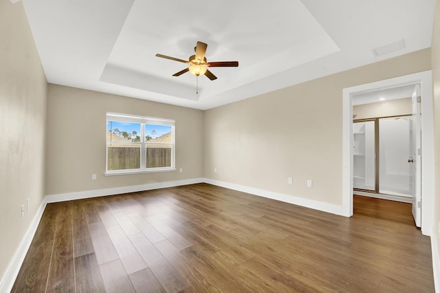 262 Bayou Bend Ln, Panama City, FL 32404 - empty room featuring a raised ceiling, dark wood-style floors, ceiling fan, and baseboards