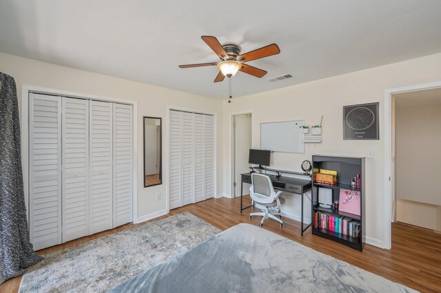 115 NE Hughes St Unit B3, Fort Walton Beach, FL 32548 - bedroom with two closets, wood finished floors, baseboards, and a ceiling fan