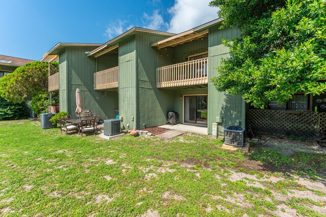 115 NE Hughes St Unit B3, Fort Walton Beach, FL 32548 - rear view of house with a balcony, a lawn, and cooling unit