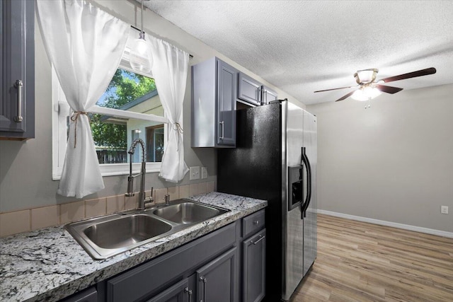 1008 Aspen Ct, Fort Walton Beach, FL 32547 - kitchen featuring a sink, fridge with ice dispenser, a ceiling fan, light wood-style floors, and a textured ceiling