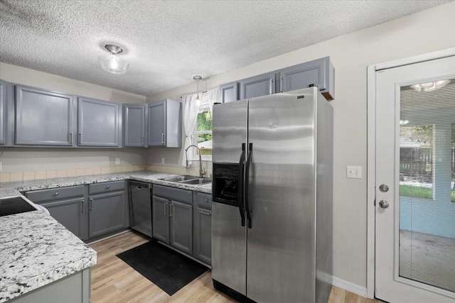 1008 Aspen Ct, Fort Walton Beach, FL 32547 - kitchen with appliances with stainless steel finishes, a sink, gray cabinetry, light wood-type flooring, and a textured ceiling