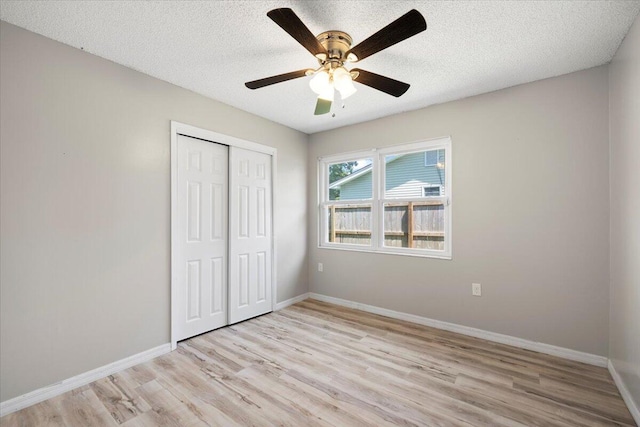 1008 Aspen Ct, Fort Walton Beach, FL 32547 - unfurnished bedroom featuring light wood-style floors, a closet, baseboards, a textured ceiling, and a ceiling fan