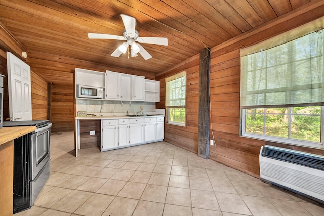 891 Choctawhatchee River Rd, Ponce De Leon, FL 32455 - kitchen featuring white microwave, light countertops, wooden walls, white cabinetry, and electric stove
