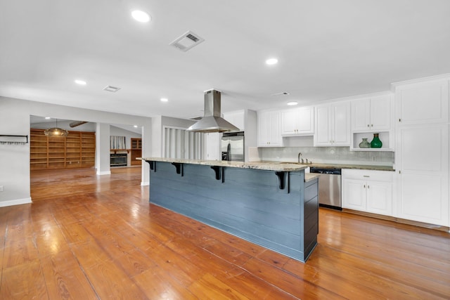 891 Choctawhatchee River Rd, Ponce De Leon, FL 32455 - kitchen with appliances with stainless steel finishes, a breakfast bar area, white cabinets, island range hood, and tasteful backsplash