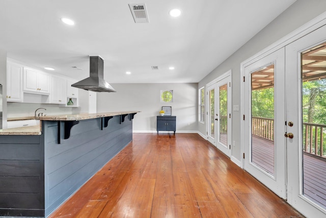 891 Choctawhatchee River Rd, Ponce De Leon, FL 32455 - kitchen featuring island range hood, a breakfast bar, white cabinets, plenty of natural light, and recessed lighting