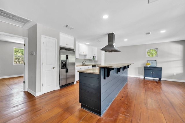 891 Choctawhatchee River Rd, Ponce De Leon, FL 32455 - kitchen featuring stainless steel fridge, island range hood, a sink, white cabinetry, and a breakfast bar area