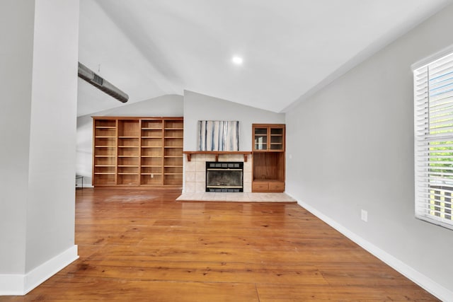 891 Choctawhatchee River Rd, Ponce De Leon, FL 32455 - unfurnished living room with a tiled fireplace, vaulted ceiling, wood finished floors, healthy amount of natural light, and baseboards