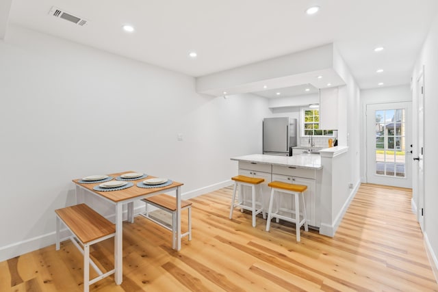 43 Summer Haven Trl Unit 3, Miramar Beach, FL 32550 - kitchen with freestanding refrigerator, a peninsula, recessed lighting, light wood-style floors, and a kitchen breakfast bar