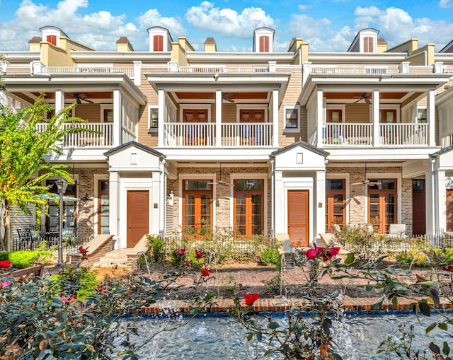 9201 Market St Inn Unit 159, Miramar Beach, FL 32550 - view of front of property featuring a balcony, ceiling fan, brick siding, and a small pond