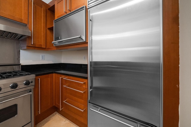 9201 Market St Inn Unit 159, Miramar Beach, FL 32550 - kitchen with stainless steel appliances, extractor fan, brown cabinetry, and dark countertops